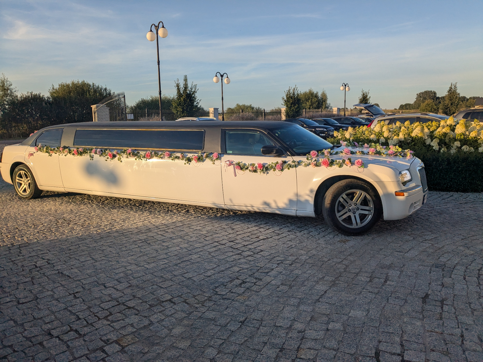 Biała limuzyna Chrysler na eleganckim podjeździe
